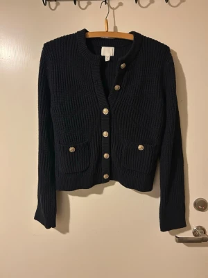 Stickad marinblå cardigan (stl S/M) - Denna stickade cardigan är en modern och smakfull klassiker, som passar både i formella samt informella sammanhang. Perfekt för dig som vill vara varm och bekväm!  (Endast använd 2 gånger)  Tveka inte att höra av dig för vidare frågor🤗  