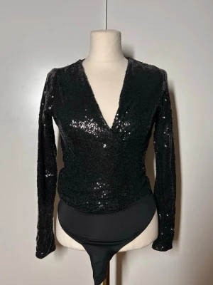 Glitter body h&m nyår - V ringaf body med paljetter, perfekt för nyår. Storlek xs.  Köp sker via köp nu, jag postar inom 24h. Kvar tills markerad såld
