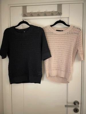 Stickade från lager 157, marinblå & beige - Två stickade från lager 157, en i marinblå (S) och en i beige (XS). Båda har korta ärmar, rund hals och ett luftigt hålmönster som ger en cool vibe.