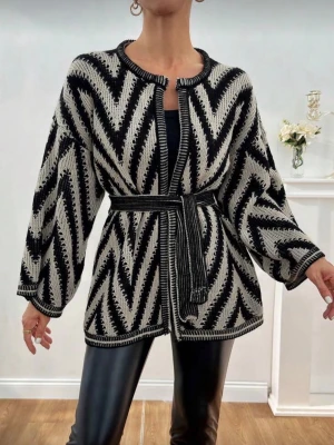 Svartvit stickad kofta med bälte - Säljer en svartvit stickad kofta med grafiskt zigzagmönster. Koftan har lång ärm, rund halsringning och ett matchande bälte i midjan för snygg passform. Perfekt till höst och vinter för en trendig och mysig look.😍❤️