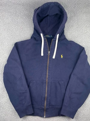 Mörkblå hoodie från polo Ralph lauren - Säljer denna snygga hoodie från polo Ralph lauren. Bra skick, inga hål eller fläckar. Skickar snabbt efter att du har beställt. Frågor? Skick ett meddelande👍