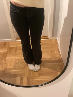 Svarta bootcut jeans från Lager 157 - Säljer ett par svarta jeans från Lager 157 med bootcut-snitt och klassisk femficksdesign. Jeansen har en hög midja och är tillverkade i ett slitstarkt jeansmaterial. Perfekta för dig som gillar en tidlös och cool look. Säljs pga jag tycker de är lite korta (jag är 172)