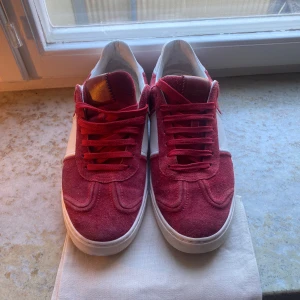 Valentino Flycrew röda mockasneakers - Säljer ett par Valentino Rockrunner sneakers i rött och vitt. Skorna är o storlek 41 men passar 42 också. Jag tar byten!!!! Obs det är ett litet hål därframme på båda skorna vid sidan där sulan är men det är ihop limmat så det är borta nu!! 