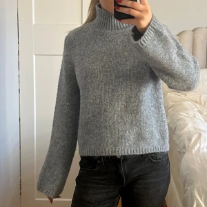 Grå stickad polotröja - Mysig grå stickad polotröja med hög krage och långärmad modell. Aldrig använd med prislapp kvar.