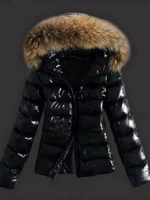 Svart glansig pufferjacka med päls - Säljer en svart glansig pufferjacka med stor luva och fluffig pälsdetalj runt huvan. Jackan har quiltad design och dragkedja framtill. Perfekt för kalla dagar när du vill vara både varm och snygg.