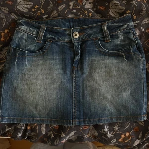 Blå vintage jeanskjol - Säljer denna snygga jeanskjol som är köpt på en marknad i Köpenhamn. Kommer tyvärr inte till användning!! 