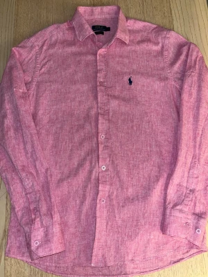 Rosa Polo Ralph Lauren skjorta - Helt ny rosa Polo Ralph Lauren skjorta, endast testad på annars helt ny, storlek M. Priset är inte hugget i sten. Tveka inte att höra av dig vid minsta fundering!