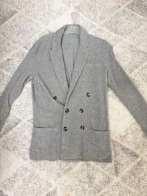 Dubbelknäppt John Henric Kavaj - Säljer en fräsch ljusgrå kavaj från John Hneric som är dubbelknäppt. Passar perfekt från krökkvällar till dejter samt även till vardagen. Storlek S men kan passa M beroende på din längd. pris kan diskuteras vid snabb affär