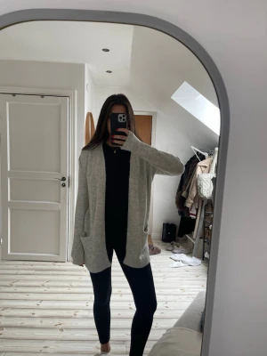 Ljusgrå stickad kofta med fickor - Mysig ljusgrå stickad kofta från new yorker.