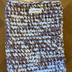 Virkat data sleeve från Fangu Atelier UF - Säljer en unik handgjord data sleeve från Fangu Atelier, mitt UF företag! Väskan är virkad i ett mönster med gammellila och vit färg. Den har en rektangulär form och är tillverkad av mjukt bomullsmaterial. Perfekt för dig som gillar coola accessoarer med personlig touch.