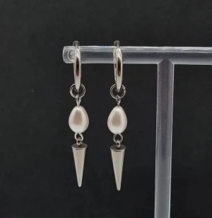 Snygga örhängen  - Snygga örhängen i silverfärg med droppformade vita pärlor och coola spetsiga spikes. Rostfritt stål.  Längd-5cm 