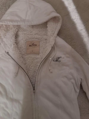 Vit zip up Hoodie Hollister fodrad  - Vit zip up Hoodie ifrån Hollister med vitt mjukt foder! Är k storlek L men passar M också 