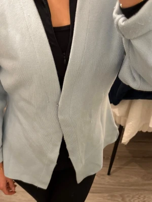 Ljusblå stickad kofta - Snygg ljusblå stickad kofta med enkel och stilren design. Använts ca 5 gånger sen har den bara legat i garderoben.  Säljs pågrund av flyttstädning