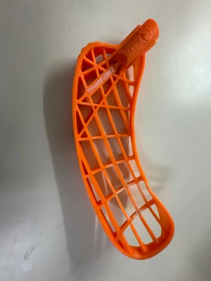 Ingen sko – orange innebandyklubba blad - Det här är ett orange blad till en innebandyklubba från Zonefloorball, modell Harder. Bladet är tillverkat i slitstark plast och har ett öppet rutmönster för medel vikt och bra bollkontroll. Perfekt för dig som vill uppgradera din klubba. Vikt 77 gram