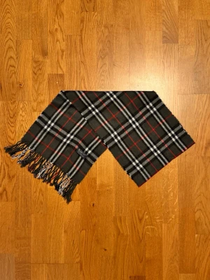 Grå Burberry halsduk - Säljer en grå halsduk från Burberry. Halsduken är gjord i lamull och är i gott skick. Var inte rädd för några frågor. Pris diskuteras inte!