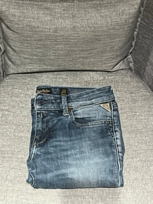Replay blå jeans bootcut dam 29/32 - Snygga blå jeans från Replay i modellen bootcut. Färgen är mellanblå med lätt slitningar för en cool look. Perfekta till sneakers eller boots. Skriv om frågor eller funderingar, pris kan diskuteras.