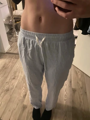 Randiga blåvita linnebyxor med snörning - Blåvita randiga linnebyxor skulle nog säga att det är pyjamas byxor dock. Knappt använda. Dem är i storleken 170 (+14)