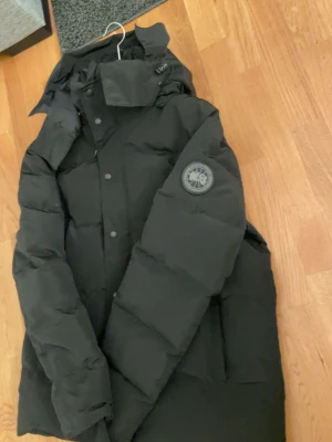 Svart vinter jacka från Canada Goose -  Säljer en Canada Goose jacka som jag fick i julklapp men tyvärr redan har i samma modell. Jackan är helt ny och aldrig använd. Storlek XL men passar även dig som vanligtvis har L. Original Canada Goose-påse och allt som följde med vid köp ingår. Inga skador, fläckar eller slitage. Hör av dig vid intresse eller frågor.