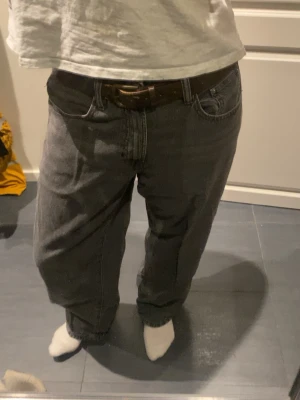 Perfekt jeans i mörkgrå denim, strl 40 - Säljer ett par mörkgrå jeans från Gina Tricot i storlek 40. Modellen har klassisk femficksdesign, raka ben och normal passform. Jeansen är tillverkade i jeansmaterial och har knapp och dragkedja framtill. Perfekt för dig som gillar en enkel och stilren look.