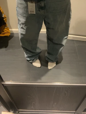 Wide jeans från YOURTURN, mid blue - Säljer ett par ljusblå jeans från YOURTURN i modellen wide. De har klassisk femficksdesign, gul kontrastsöm och är tillverkade i jeansmaterial. Passformen är loose och byxorna har low midja. Perfekt för dig som gillar avslappnad stil och breda ben. Helt nye