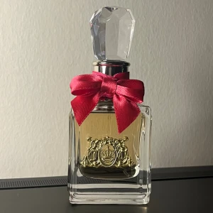 Juicy Couture Viva La Juicy parfym - Viva La Juicy från Juicy Couture, 30 ml Eau de Parfum. Snygg flaska med röd rosett och guldiga detaljer. Perfekt storlek att ta med i väskan. Helt oanvänd.