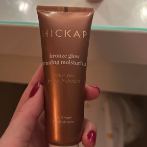 Hickap Bronze Glow Primer & Miracle Blur - Bronze Glow Priming Moisturizer i bronsfärgad tub som ger glow och återfuktar, den är vegansk och perfekt för en fräsch bas.