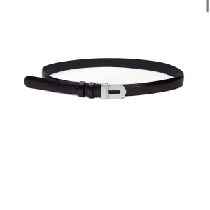 Svart skärp med silverfärgat spänne - Stilrent svart bälte från teurn studios i 100% skinn med ett smalt, elegant silverfärgat spänne. Passar till både jeans och kostymbyxor. Helt nytt med prislapp kvar. Ny pris 3500kr på NK. Vet inte vad det är för mått/storlek.