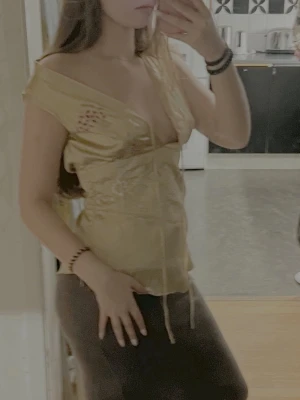 Guldig topp - Supersöt guldig topp från Designers Remix i glansigt material med broderade blommor i rosa och vitt.  Aldrig använd och säljs ej längre💕