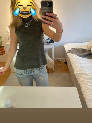 Mörkgrå polotopp från Zara - Säljer en stilren mörkgrå polotopp från Zara i storlek S. Toppen är ärmlös och har en hög polokrage som ger en clean och modern look. Materialet är mjukt och stickat, perfekt för layering eller att bära som den är. Passformen är normal och toppen är enkel att matcha.