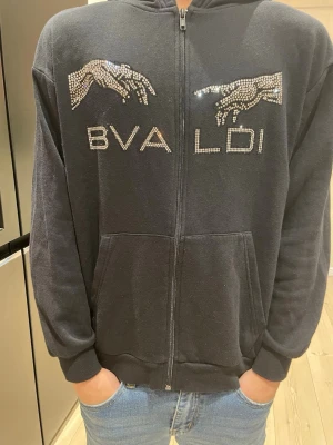 Bvaldi hoodie - Svart bvaldi hoodie med rhinstone på framsidan av tröjan.