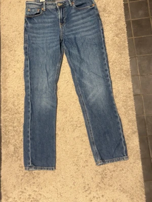 Blåa Jack & Jones jeans regular Clark - Säljer ett par blå jeansbyxor i klassisk rak modell med fem fickor och normal passform. Jeansen har en tidlös look med ljus tvätt och traditionella sömmar. Perfekta för dig som gillar enkel och stilren denim.