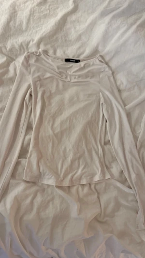 Vit långärmad topp från Bik Bok - Säljer denna jätte fina vita långärmade tröjan från BikBok med slits och rundringad vid halsen. Säljer då den inte kommer till användning. Skriv för mer bilder!🩷