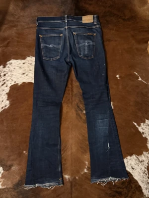Flared nudie - Tjena! Säljer dessa riktigt feta raw denim flared jeans, byxorna är i W34/L36 men skulle säga att dom passar bättre om du har W32 i vanliga fall då dom är lite tighta på mig som brukar ha W34, hör av dig vid funderingar!🙌