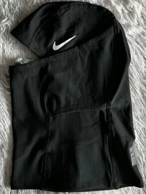 Svart ski mask - Ski masken  är tillverkad i ett syntetmaterial som håller värmen och har en tight passform. Perfekt för träning under kyliga dagar. Snygg detalj med Hyperwarm-tryck på insidan.