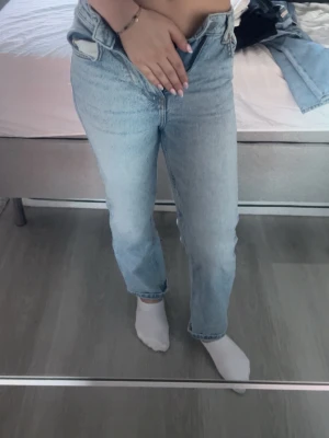 Ljusblåa low straight jeans - Säljer ett par klassiska ljusblå  jeans med hög midja och rak passform. Jeansen har fem fickor, knappgylf och är tillverkade i slitstarkt bomullsjeansmaterial. Perfekt för dig som gillar en tidlös och chill stil. Säljer då jag fick i julklapp men är för små för mig