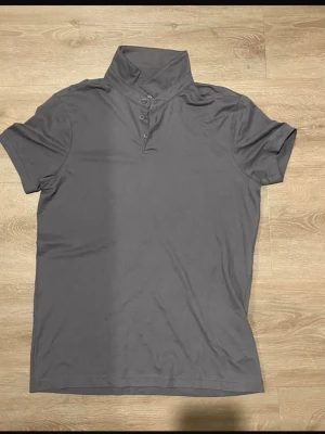 Grå Piké fit t-shirt från H&M - Säljer en grå piké tröja från HM. Tröjan börjar bli liten. Endast 30kr. 