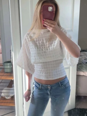 Vit croppad blus från Nelly - Säljer en vit croppad blus från Nelly i storlek XS.