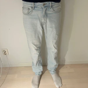 Ljusblå straight jeans från Zara - Säljer ett par ljusblå Zara jeans med klassisk femficksdesign och raka ben. Jeansen har normal passform och är tillverkade i jeansmaterial. De har en ljus tvätt och detaljer som knapp och dragkedja framtill samt Zara patch bak i midjan.