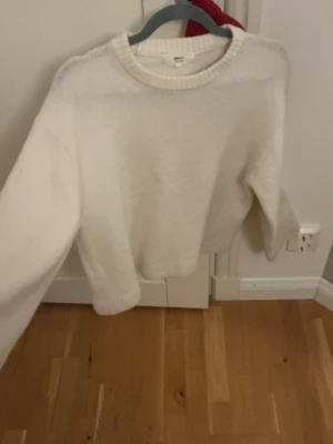 Vit stickad tröja från Gina Tricot - Mysig vit stickad tröja från Gina Tricot i storlek XS. Tröjan har rund hals, ribbade muddar och är tillverkad i en mjuk ullblandning. Perfekt för kyliga dagar och enkel att matcha med jeans eller kjol.