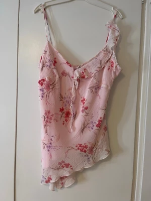 Ljusrosa blommig topp med volang - Jättefin ljusrosa topp som jag har köpt från secondhand butiken Y2k Vintage i London. Den är i mycket bra skick utan några defekter i storlek M. 
