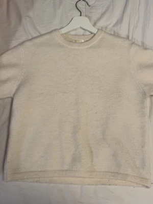 Beige stickad tröja från Gina Tricot - Mysig beige stickad tröja från Gina Tricot i storlek 158/164. Tröjan har rund hals och är kortärmad. Perfekt för att hålla sig varm under kyliga dagar och passar till många olika stilar.