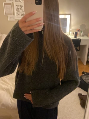 Mörkgrå stickad tröja med half zip - Mysig mörkgrå stickad tröja med half zip framtill. Tröjan har en loose passform och långa ärmar, perfekt när de är lite kallt!💞