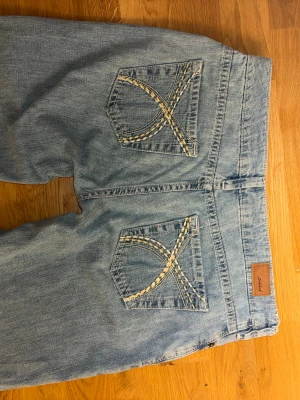 Subdued wide jeans  - Ljusblå jeans från Subdued i wide leg-modell med raka ben. Snygga broderade detaljer på bakfickorna i beige och vit. Storlek 34 och aldrig använda, nypris runt 1000kr 