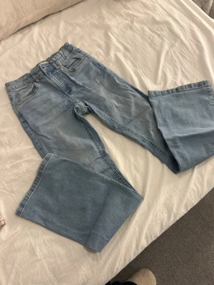 Ljusblå wide jeans från Denim Day - Säljer ett par ljusblå jeans från Denim Day i storlek 158. Modellen har breda ben och klassisk femficksdesign med knapp och dragkedja framtill. Jeansen är tillverkade i mjukt denimtyg och har en snygg, avslappnad passform.