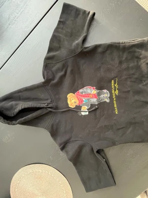 Polo Ralph lauren hoodie  - Säljer en Polo Ralph lauren hoodie som har ett tryck som är en björn, Tröjan är i storlek S, men enligt mig så är den nog lite mindre än storlek S. Hör av er vid frågor! 