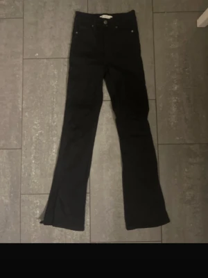 Svarta Molly bootcut jeans XXS - Säljer ett par svarta Molly jeans från Gina Tricot i storlek XXS. Byxorna har bootcut-modell med hög midja och klassisk femficksdesign. Tillverkade i stretchig bomullsblandning och har dragkedja framtill. Perfekta till sneakers eller boots. Byxan har slits vid bena. Oanvänd