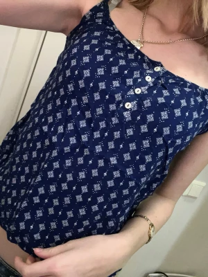 Gulligt marinblått linne från divided - Superfint linne med så snygg modell! Knapparna och mönstret är så fint. Passar lite litet på mig och jag har ofta storlek S ibland XS.