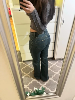 Blå bootcut jeans med pärldetaljer - Säljer ett par blå hightwaist bootcut jeans med fina silverdetaljer, måtten ser ni på bilderna men tveka inte att ställa frågor💗