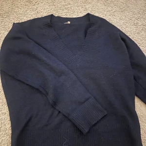 Mörkblå stickad v-ringad tröja  - Mysig mörkblå stickad tröja med v-ringning och långa ärmar. Storlek S, bra skick.