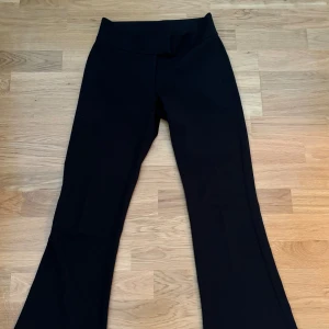 Svarta bootcut kostymbyxor - Svarta kostymbyxor med bootcut-silhuett och låg midja. Byxorna har en bred linning och diskreta bakfickor. Snyggt skräddade och i ett mjukt, följsamt tyg som ger en clean look. Fint skick. 